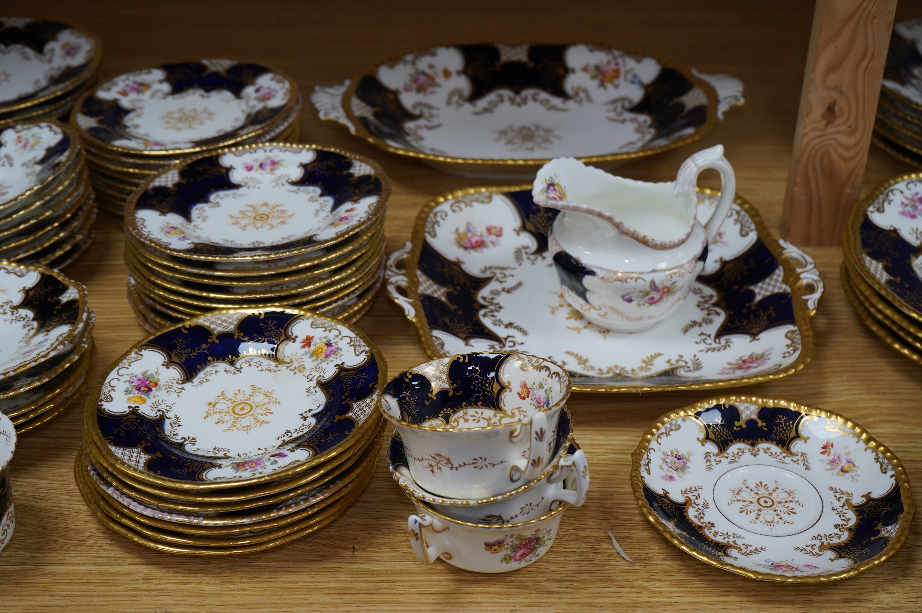 A late 19th/early 20th century Coalport blue and gilt bordered floral painted part tea and dessert service, largest 32cm wide. Condition - varies
